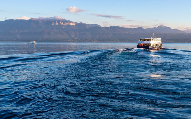 Ferry crossing Lake Geneva from Lausanne to Evian with mountain backdrop.