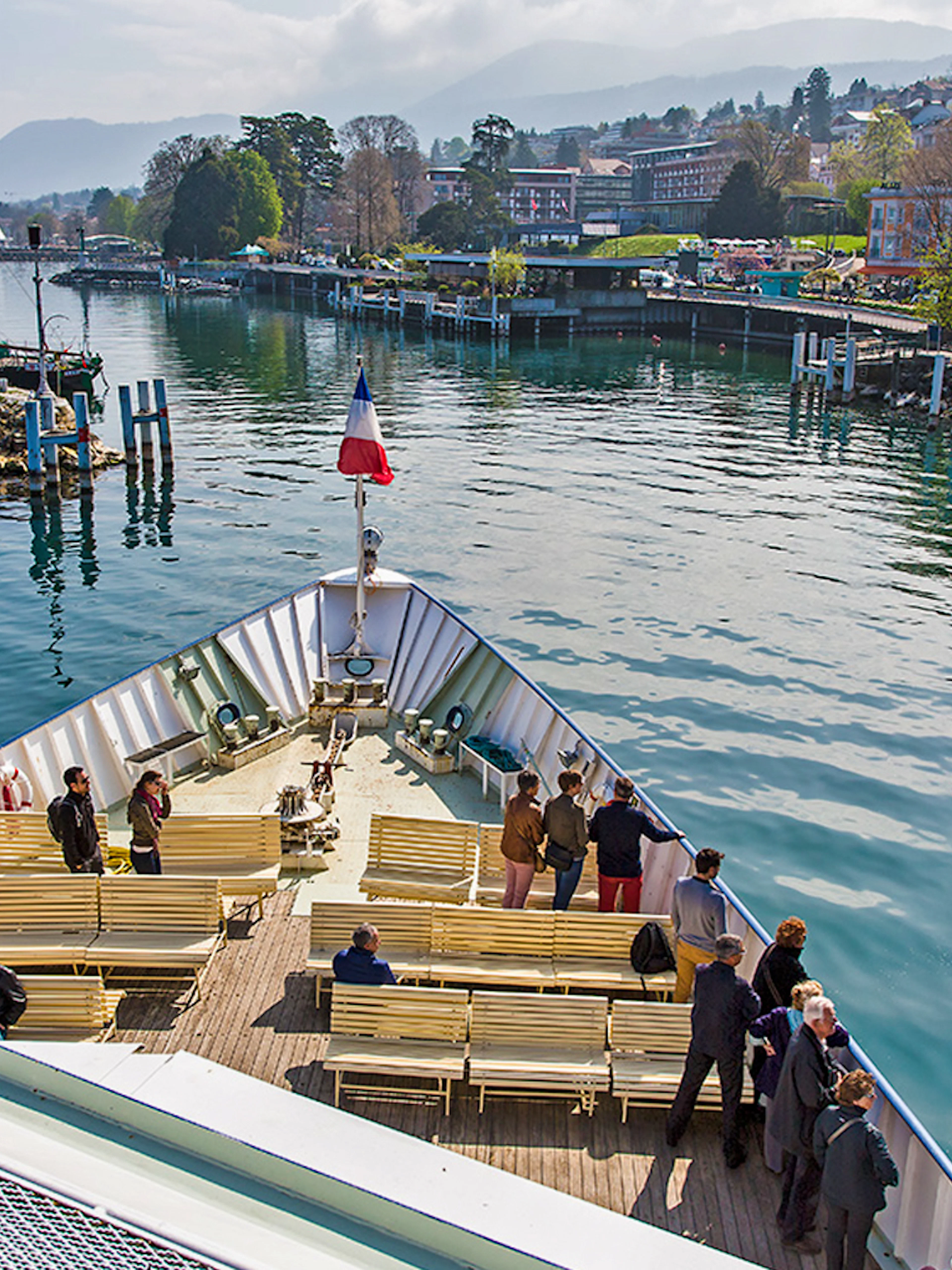 Ferry departing from Lausanne to Evian with passengers on deck, scenic waterfront view.