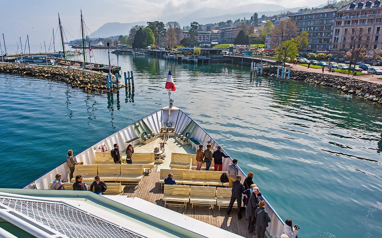 Ferry departing from Lausanne to Evian with passengers on deck, scenic waterfront view.