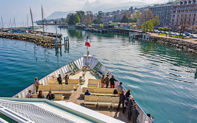 Ferry departing from Lausanne to Evian with passengers on deck, scenic waterfront view.