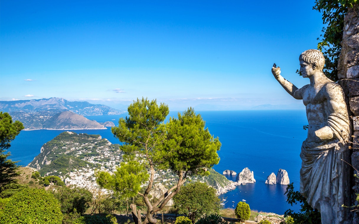 Capri island view with Faraglioni rocks and statue from Naples port tour.