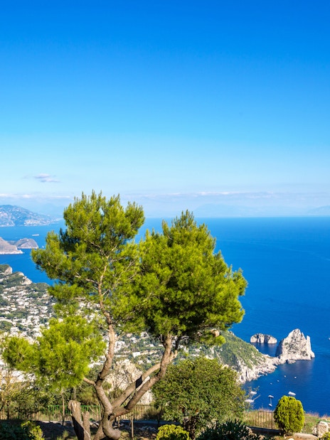 Capri island view with Faraglioni rocks and statue from Naples port tour.