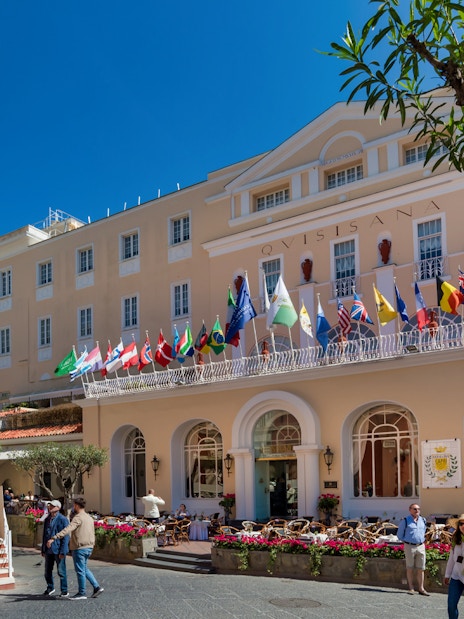 Elegant building with international flags in Capri, Italy, part of the Capri Full Day Private Tour from Naples Port.