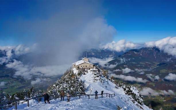 Eagle’s Nest in snow-covered mountains with visitors, view from Salzburg tour.