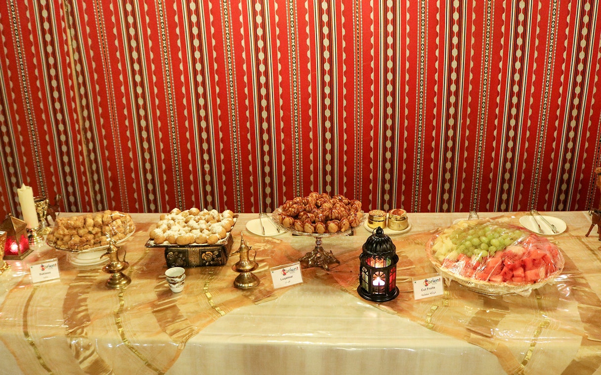 Traditional Middle Eastern dessert spread with lantern, part of Desert Wonder evening safari experience.
