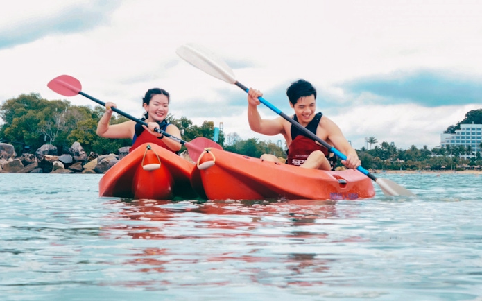 People kayaking at Ola Beach Club, Sentosa, Singapore.
