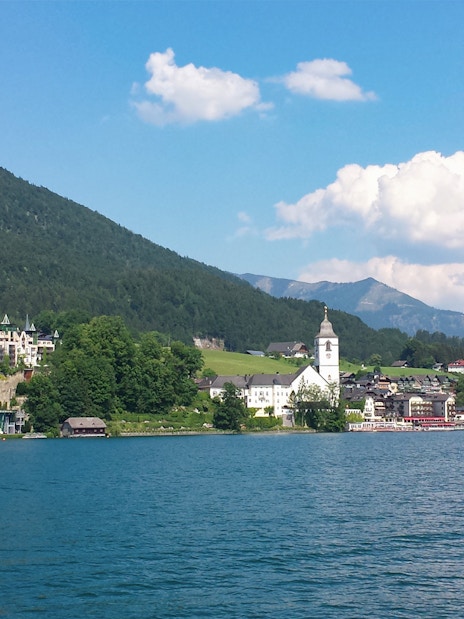 Salzburg lakeside village with church and mountains, part of Sound of Music and Salt Mines tour.