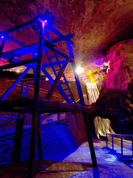 Salt mine interior with colorful lights and wooden slides, Salzburg tour.