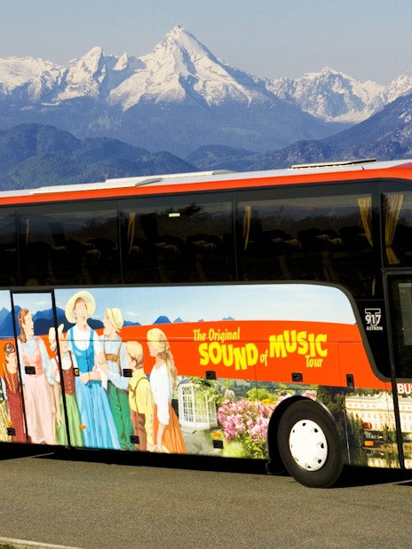 Tour bus for Salzburg Sound of Music and Salt Mines against Alps backdrop.