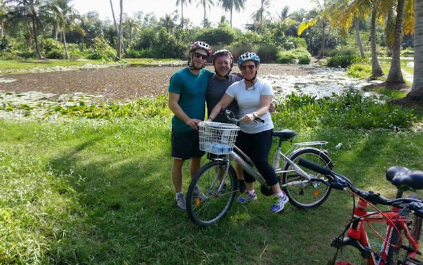 Cyclists posing with bikes near a pond on Pulau Ubin cycling tour.