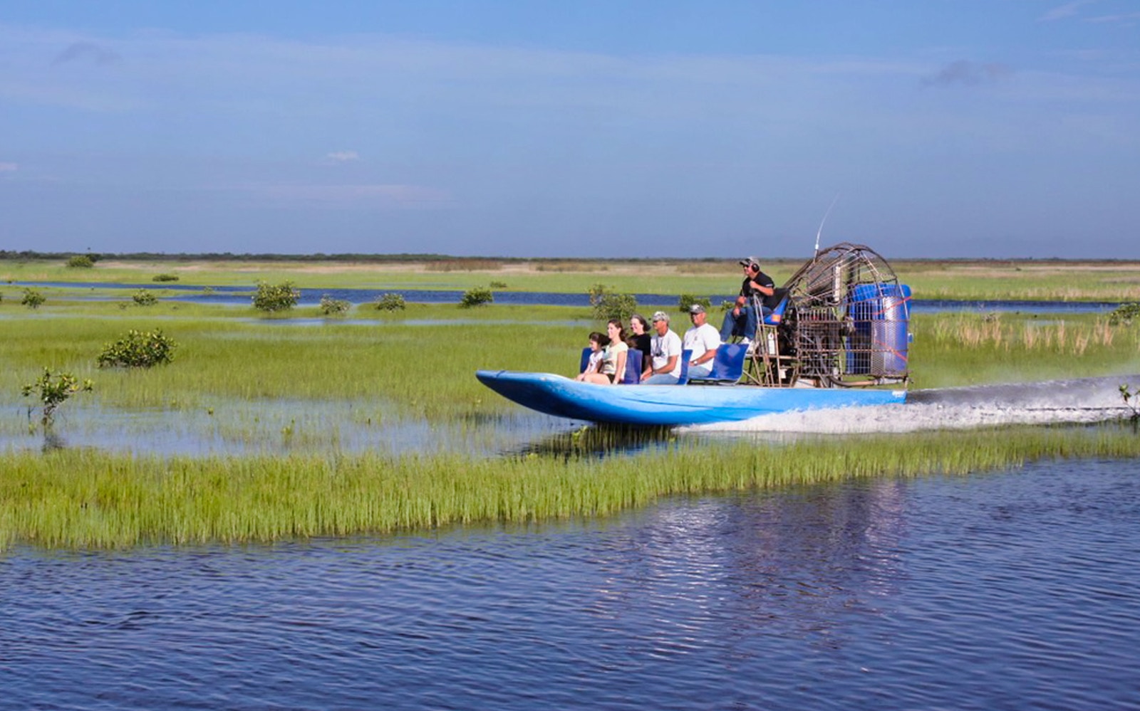 Airboat gliding through Everglades marshland on tour from Miami.