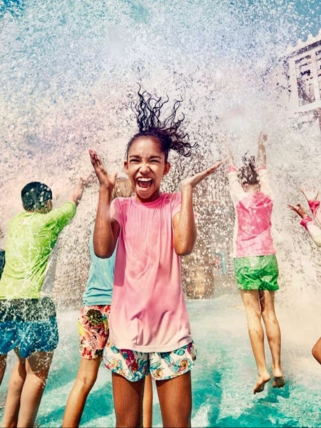 Children playing under water splash at Yas Waterworld, Abu Dhabi.