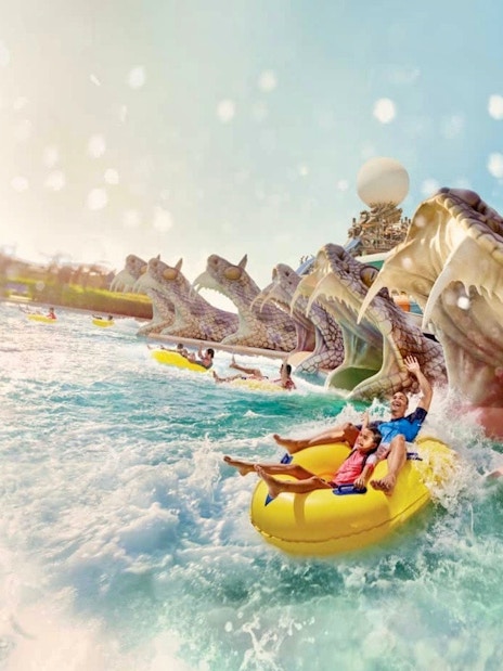 Visitors enjoying a water ride at Yas Waterworld, Abu Dhabi, with dragon-themed slides.