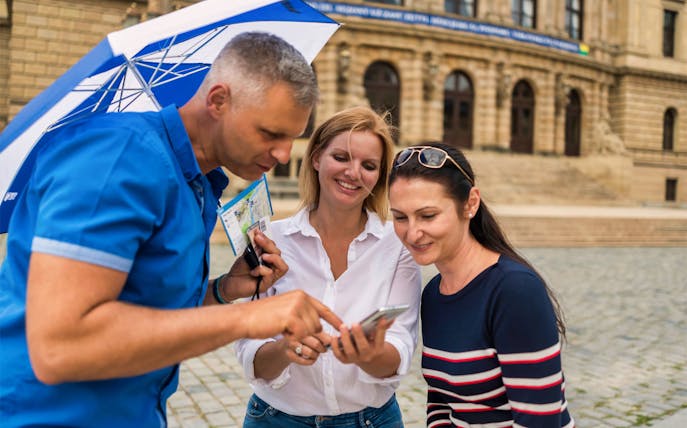 Tourists with guide using phone for Jewish Quarter tour directions.