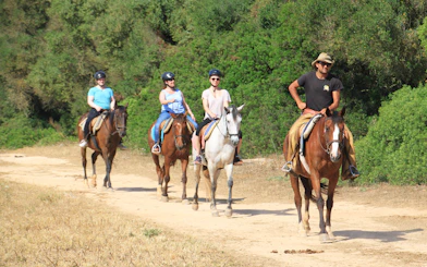 Horseback riders on a sandy trail near the beach in Mallorca.
