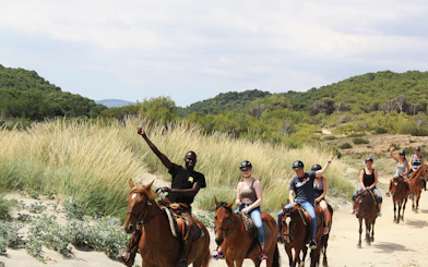 Horseback riders on a sandy trail near the beach in Mallorca.
