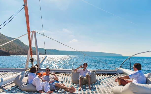 Group relaxing on a catamaran deck during Palma de Mallorca tour.