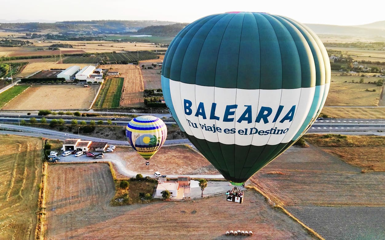Hot air balloons floating over Mallorca countryside during a scenic ride.