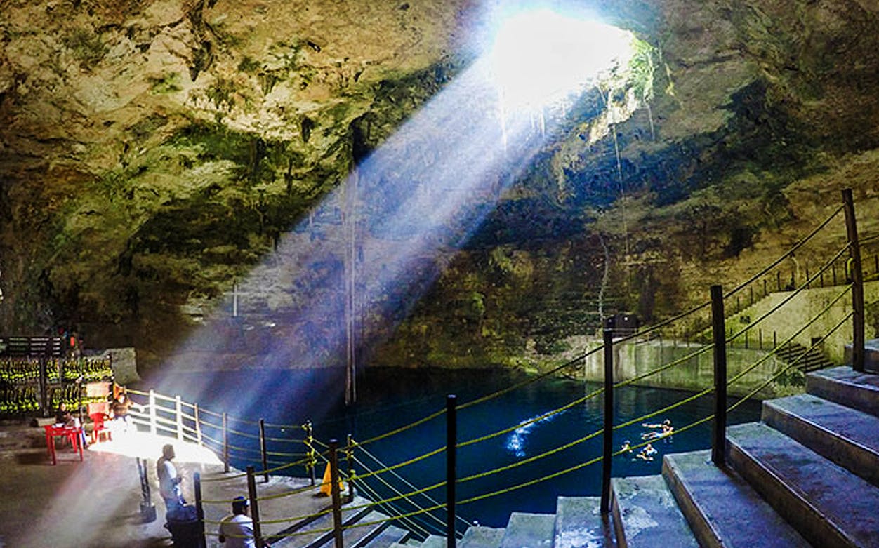 Cenote Hubiku with sunlight streaming through the opening, part of Chichen Itza Ekbalam tour.