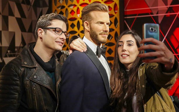 Visitors taking a selfie with a wax figure at Madame Tussauds Istanbul.