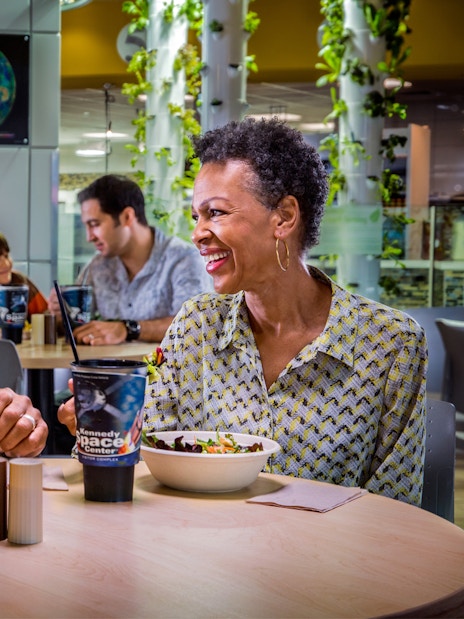 Couple enjoying a meal at Kennedy Space Center cafe during guided tour.