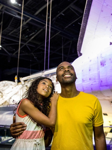 Visitors admiring a space shuttle at Kennedy Space Center, part of the ICON Park tour.