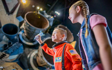 Children exploring a space shuttle exhibit at Kennedy Space Center.