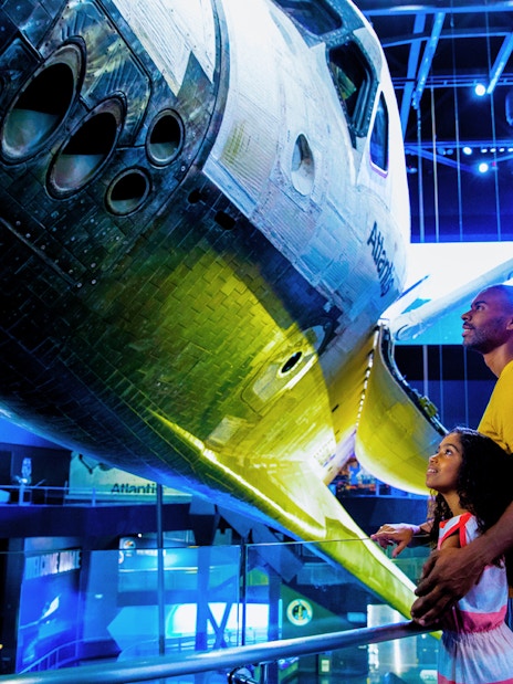Visitors admiring space shuttle Atlantis at Kennedy Space Center.