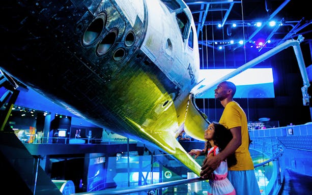 Visitors admiring space shuttle Atlantis at Kennedy Space Center.