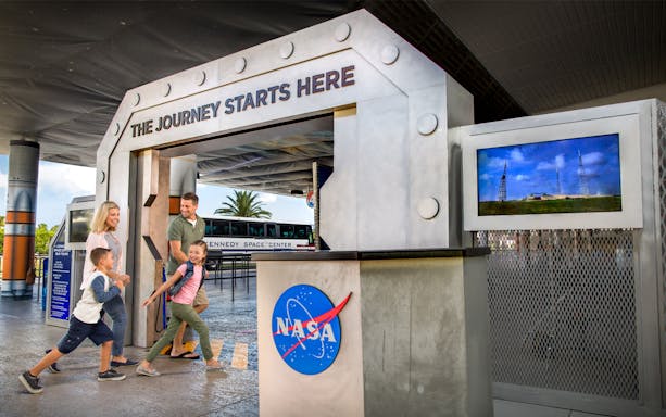 Family entering Kennedy Space Center entrance for VIP tour experience.