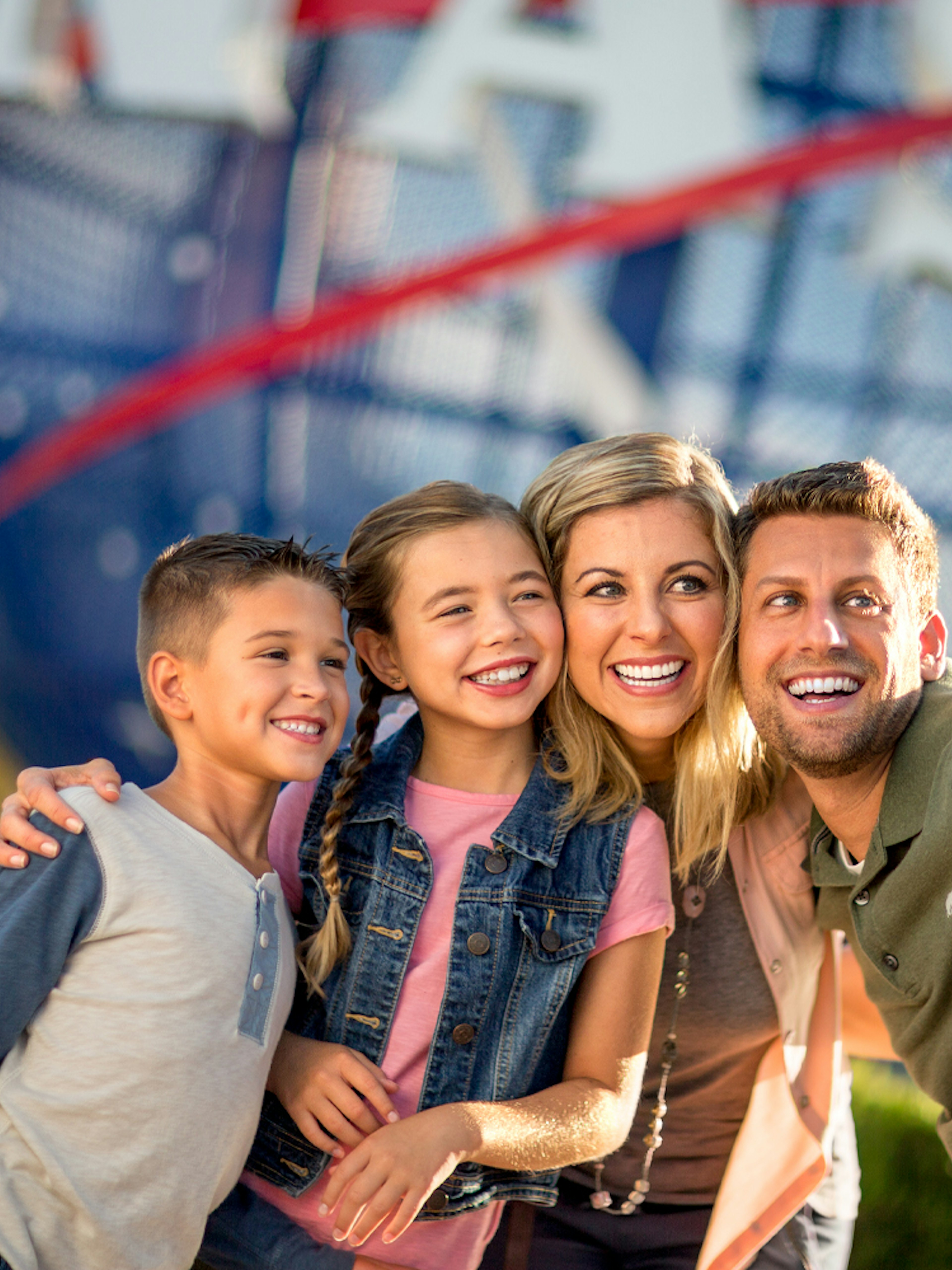 Family taking a selfie at Kennedy Space Center with NASA globe in background.