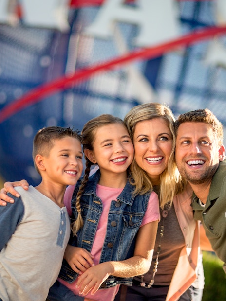 Family taking a selfie at Kennedy Space Center with NASA globe in background.