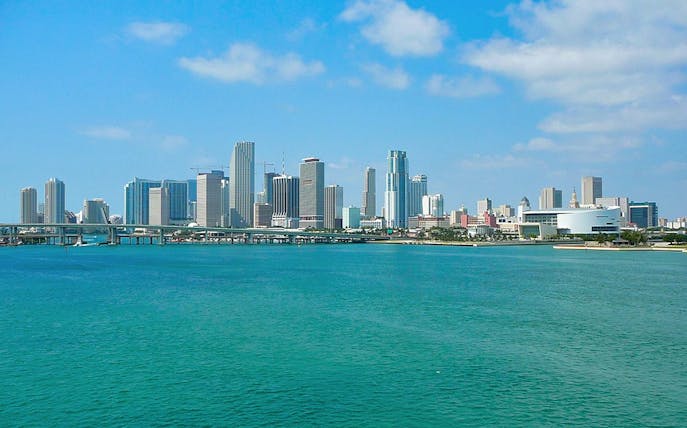 Miami skyline view from the bay, featuring high-rise buildings and clear blue water.