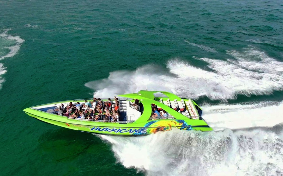 Speedboat with passengers cruising through Miami waters on a sightseeing tour.