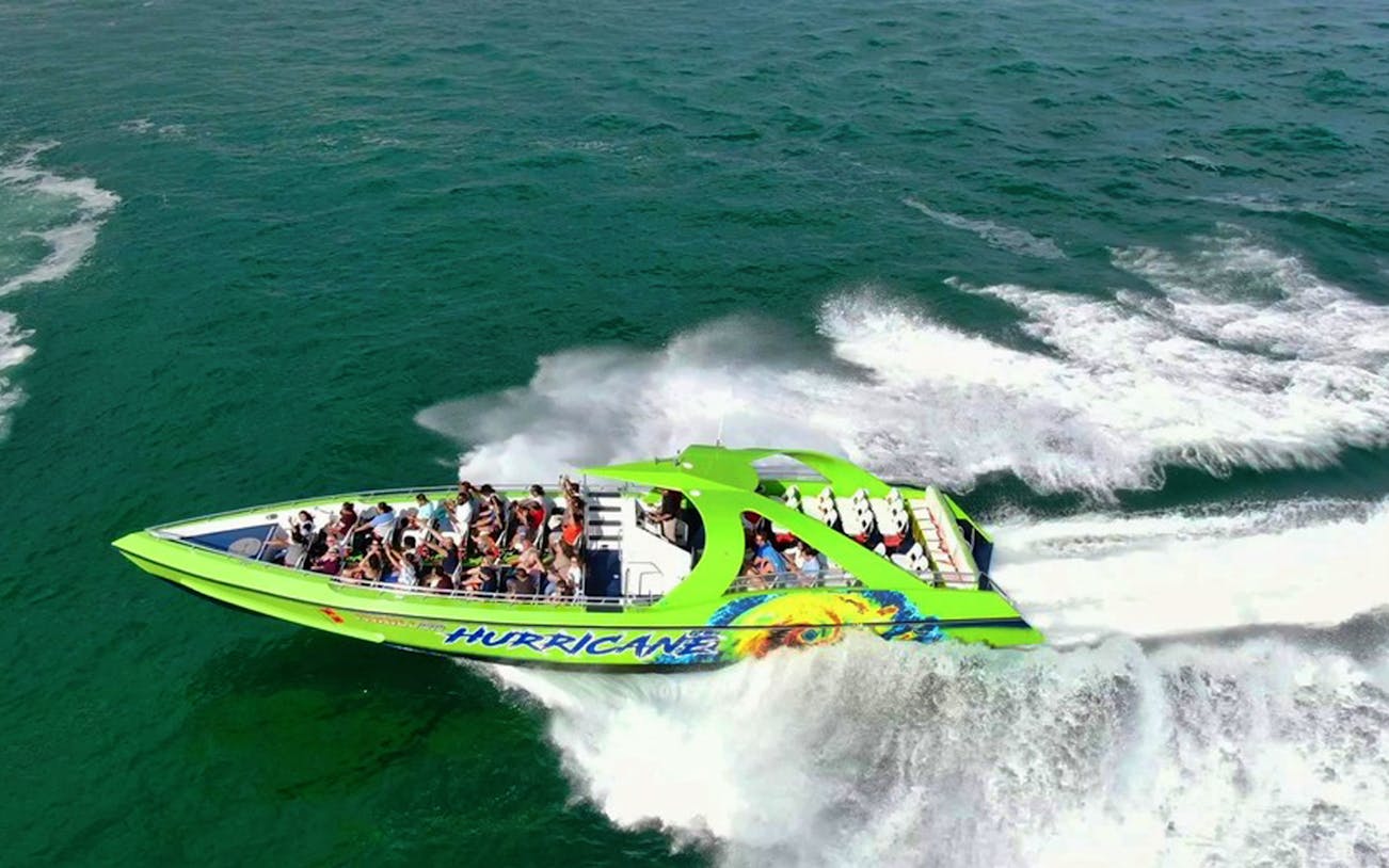 Speedboat with passengers cruising through Miami waters on a sightseeing tour.