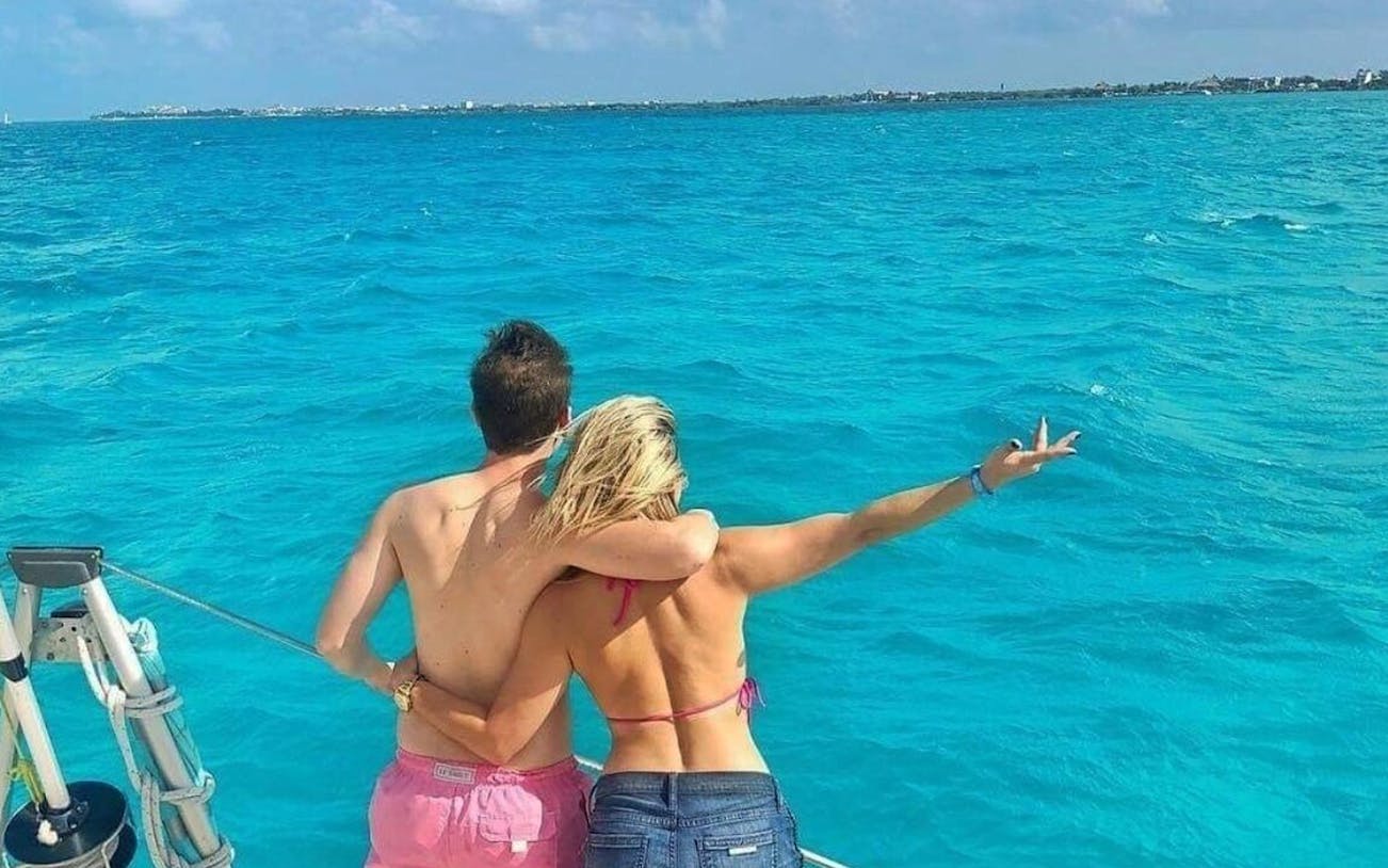 Couple enjoying view on catamaran, Isla Mujeres tour.