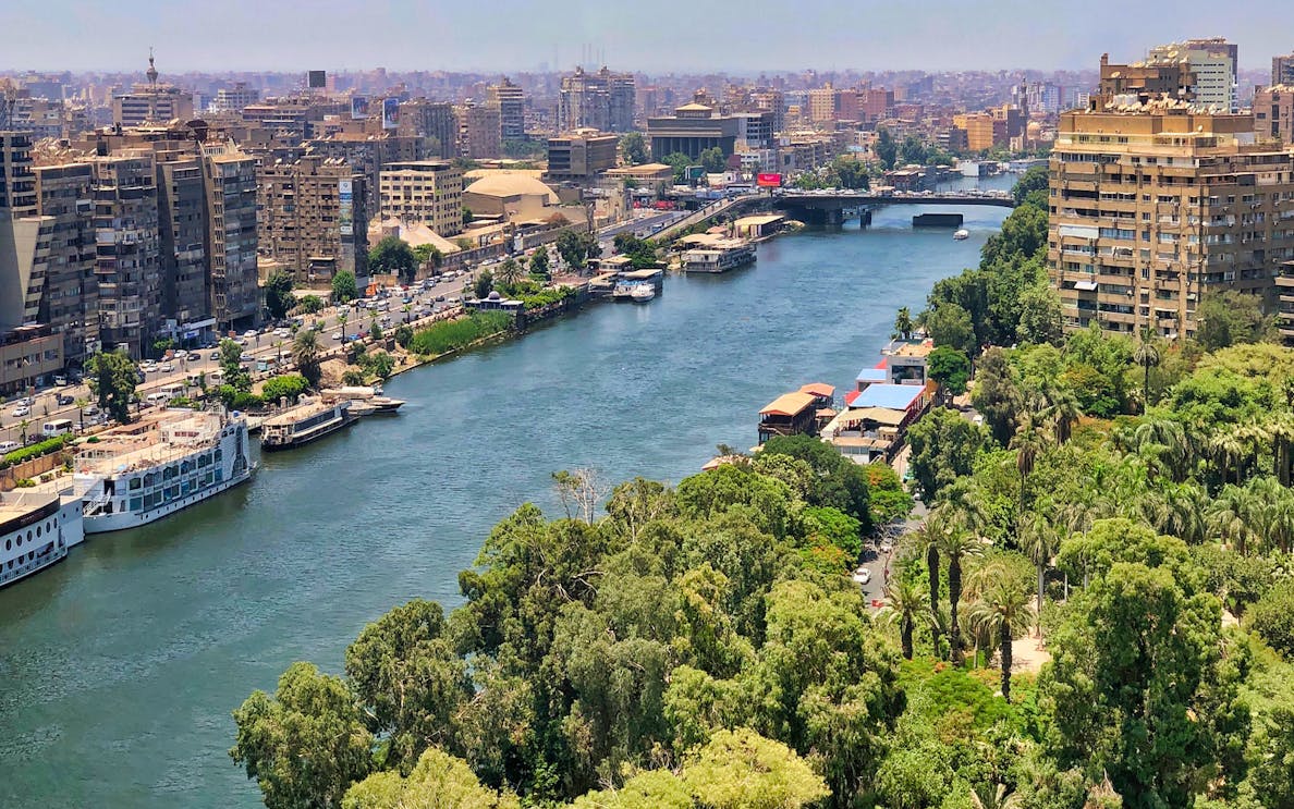 Nile River with cruise boats and Cairo cityscape in the background.