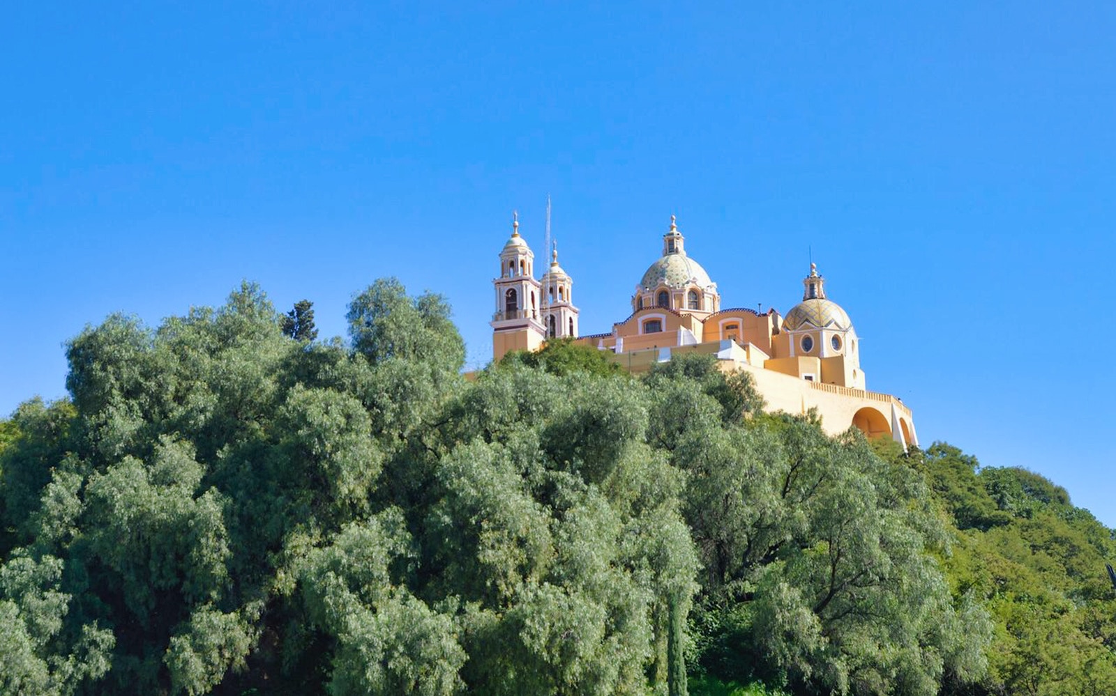 Teotihuacan tour view of the Guadalupe Shrine atop a hill with clear blue sky.