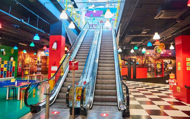 Escalator inside Legoland Discovery Center Istanbul with colorful decor and Lego figures.