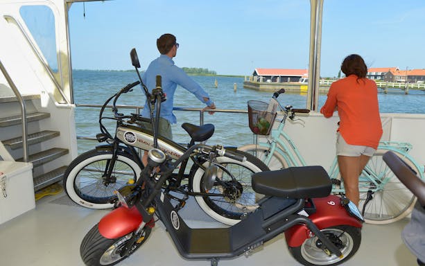 E-scooter and bicycles on a boat during Volendam, Monnickendam, and Marken tour.