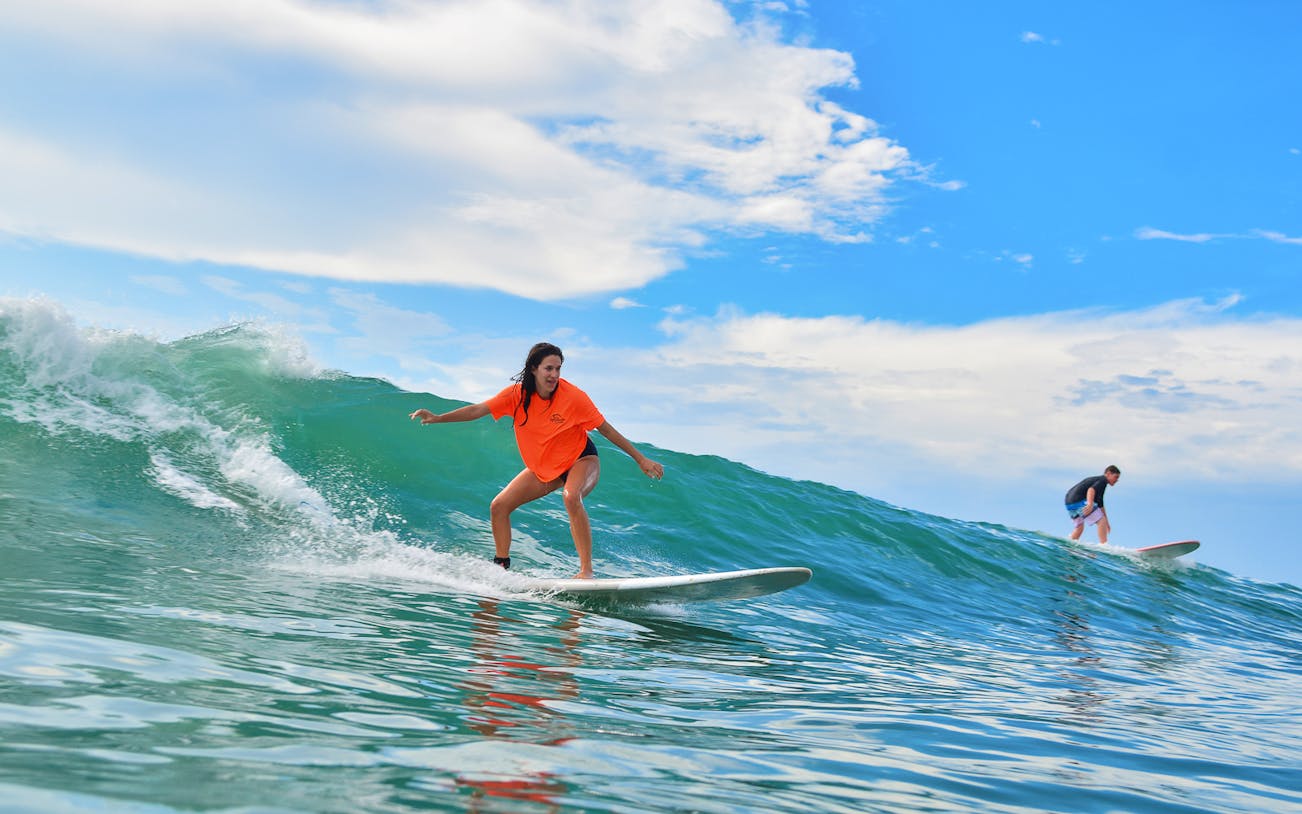 Surfers riding waves during lessons at Costa Azul, Mexico.