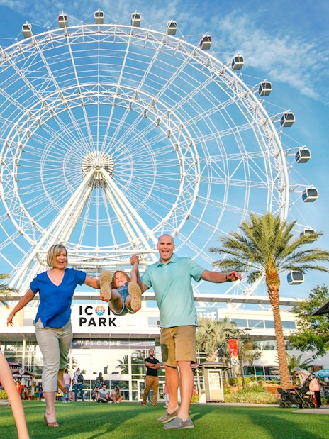 Family enjoying a day at ICON Park with the Ferris wheel in the background.