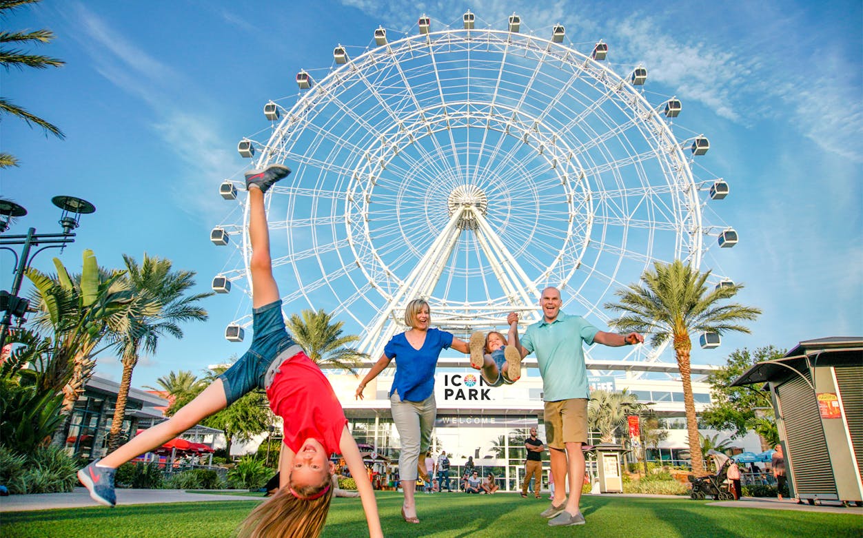 Family enjoying a day at ICON Park with the Ferris wheel in the background.