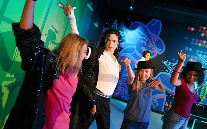 Visitors posing with a wax figure at Madame Tussauds Orlando.