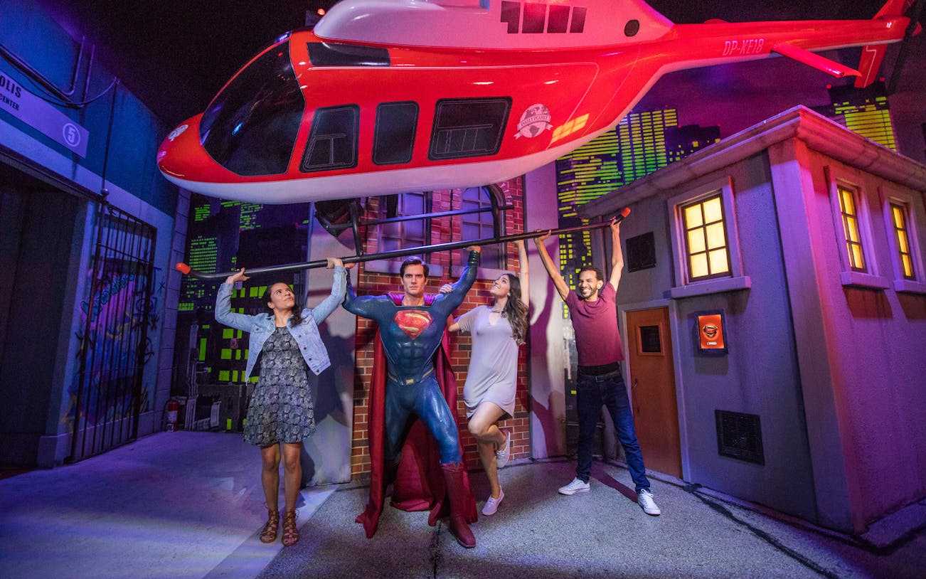 Visitors posing with Superman wax figure at Madame Tussauds Orlando.