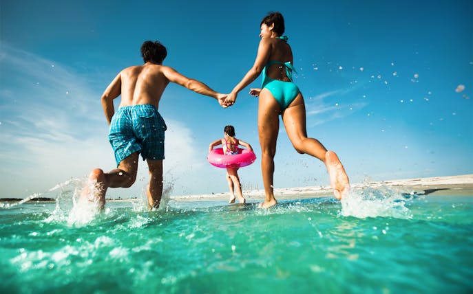 People running into the ocean at Clearwater Beach, Florida.