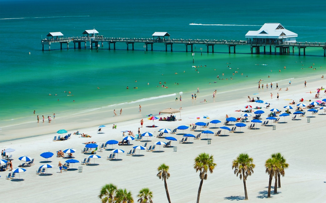 Clearwater Beach with umbrellas and people near Pier 60, Florida.