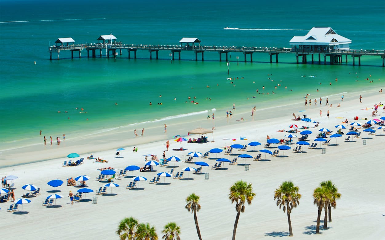 Clearwater Beach with umbrellas and people near Pier 60, Florida.