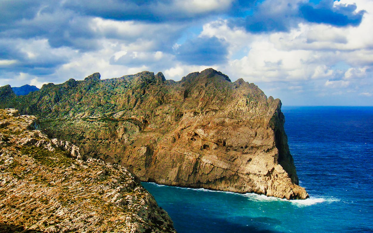 Rocky coastline of Palma Mallorca with cliffs and blue sea.
