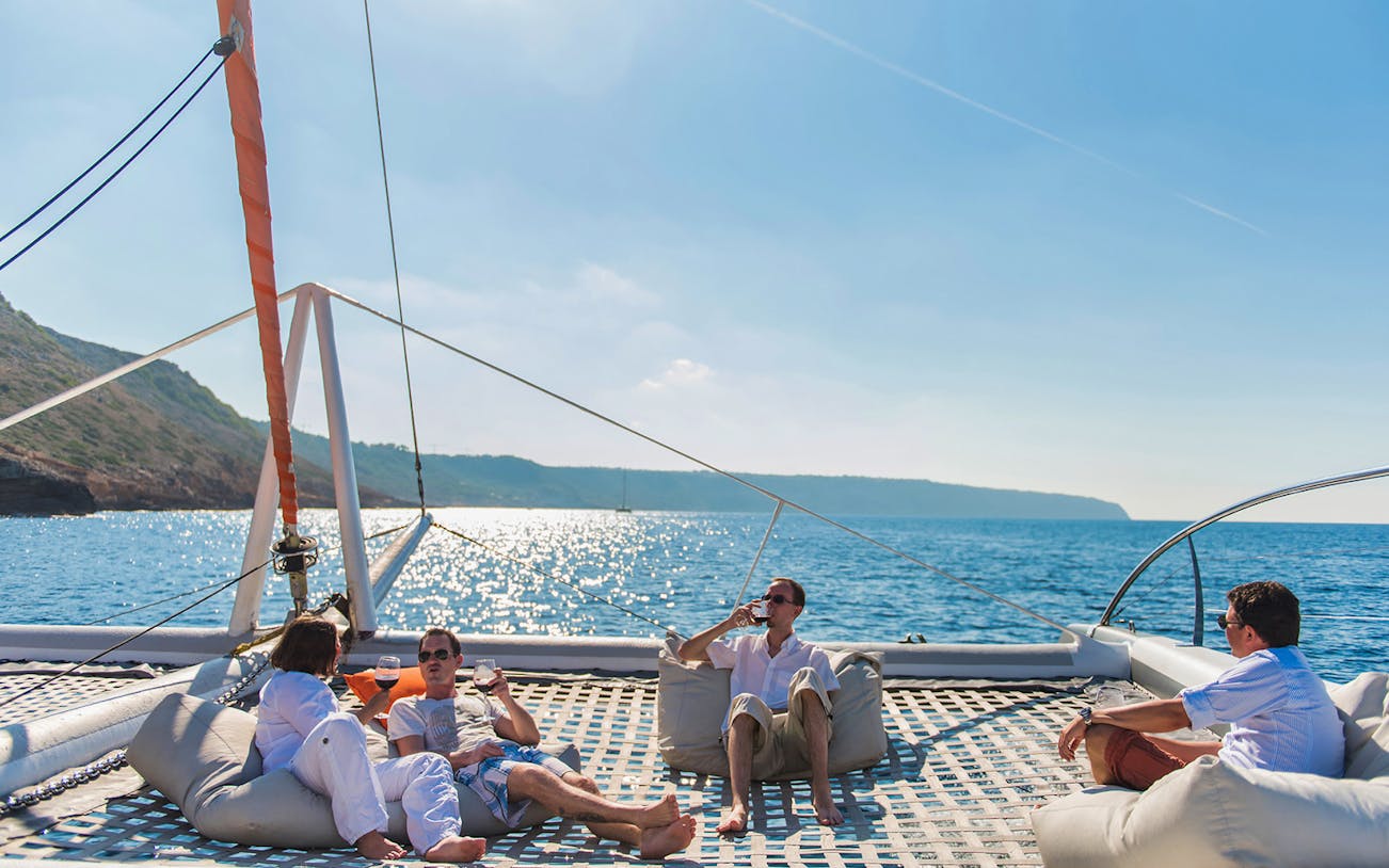 Group relaxing on a catamaran during an Alcudia excursion with a local guide.